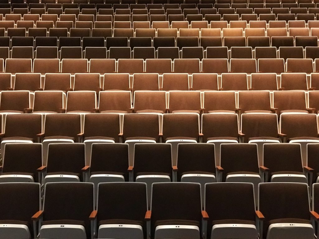 rows of empty brown leather theatre seats in a theatre that shows branded entertainement