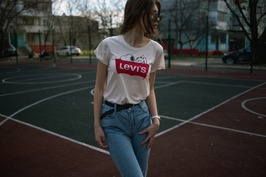 woman on basketball court in levi's tee and mom jeans