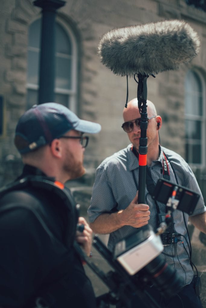 man holding a boom microphone 