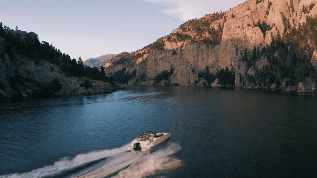 aerial videography of a boat on a lake in Montana near a mountain