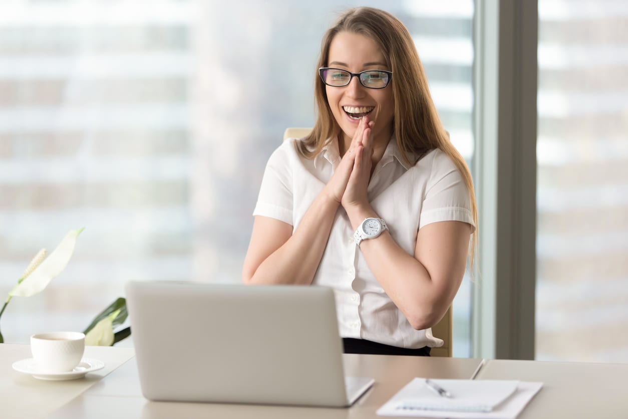businesswoman laughing about brand storytelling on her computer