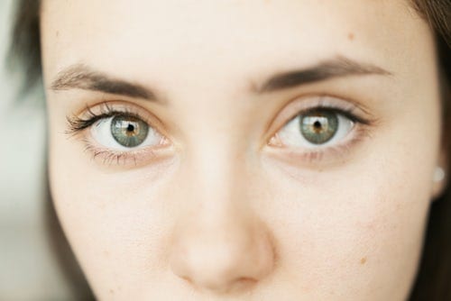 close-up photo of woman's face with green eyes and dark hair
