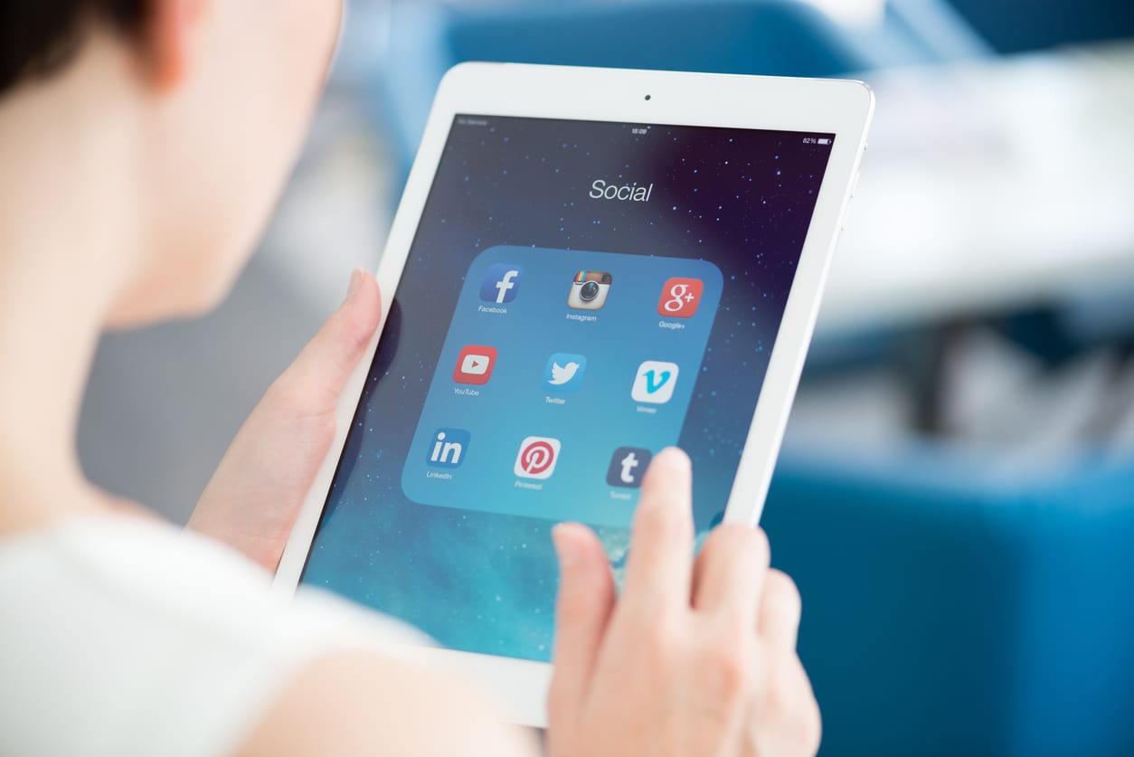 cropped-photo-of-woman-holding-tablet-displaying-social-media-icons