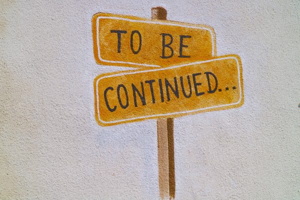 painting-of-orange-sign-on-brown-post-saying-to-be-continued-in-capital-letters