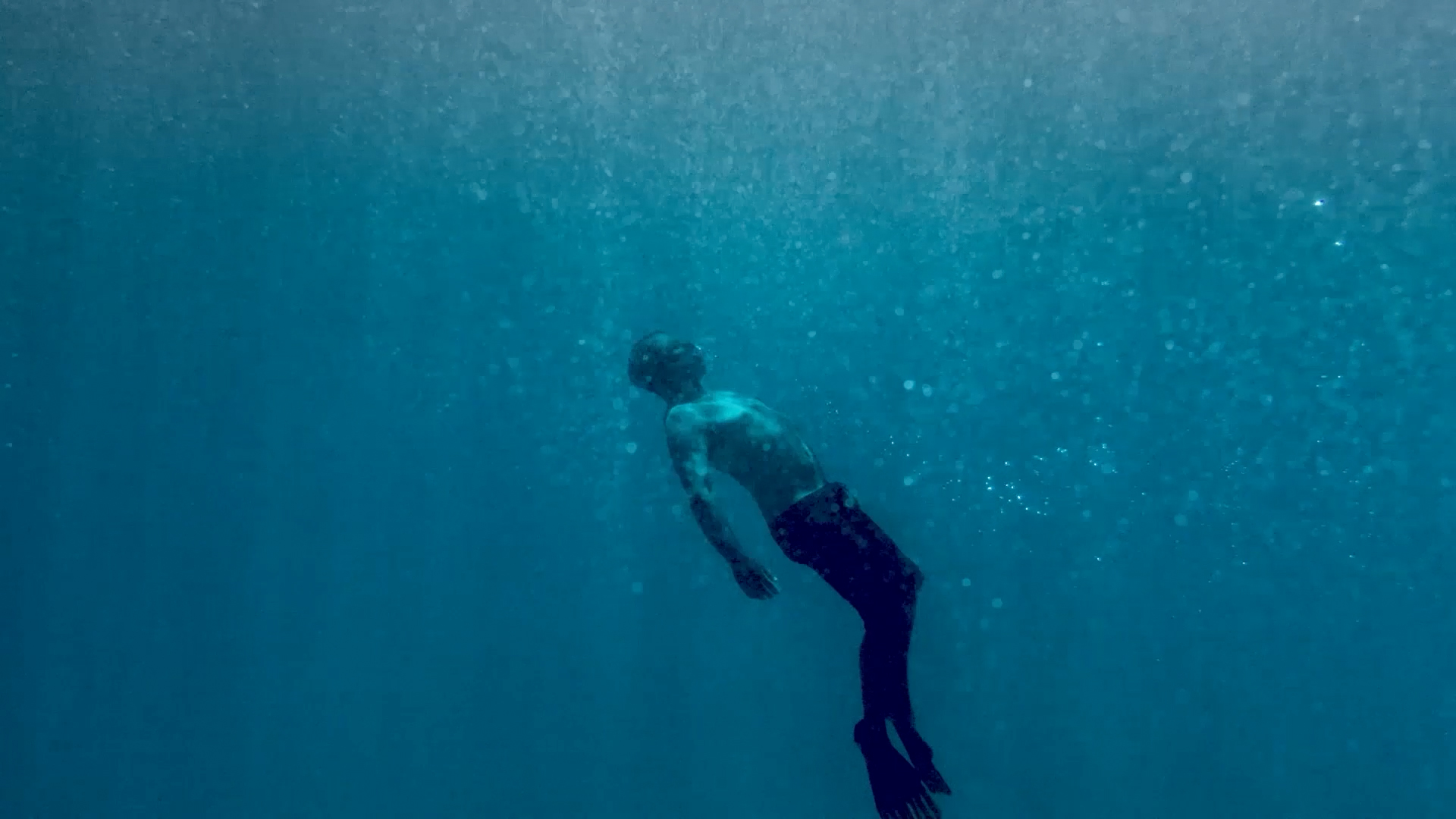 waterman floating under ocean surface