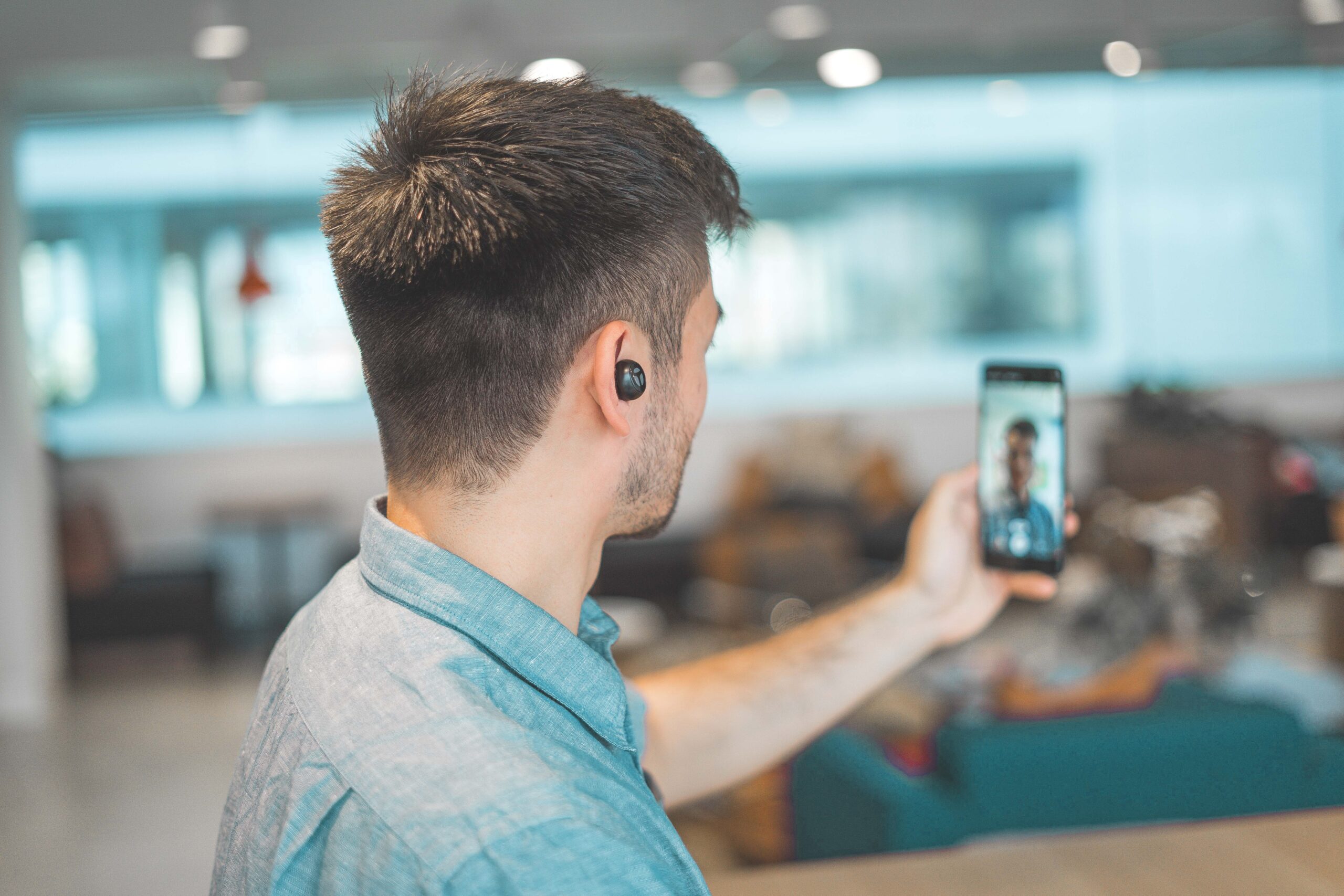 man creating short form video content on in phone in the office.